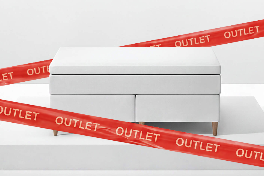 Outlet s&auml;ng vit med r&ouml;da band med outlet text p&aring; 