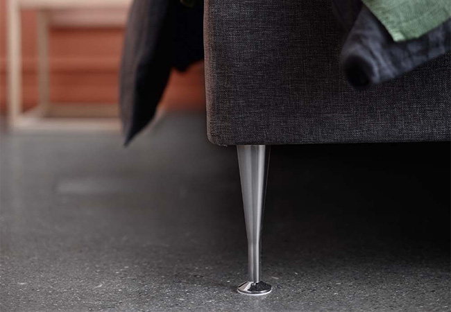 Höga silverfärgade metall sängben på en mörk grå säng Höga silverfärgade metall sängben på en mörk grå säng