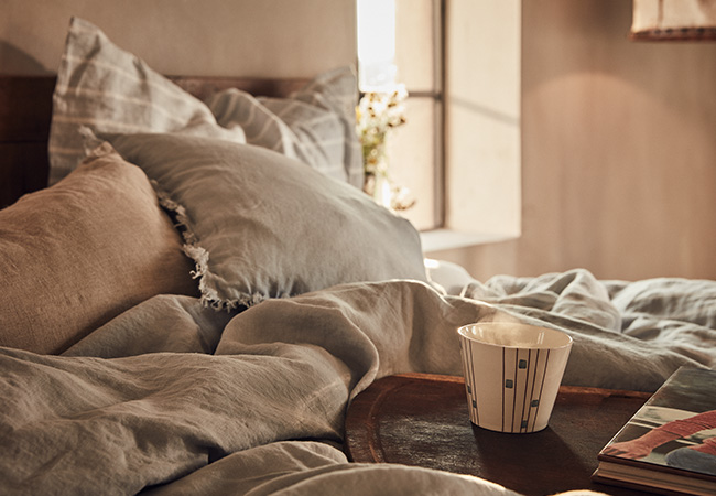 Vackert bäddad och varm sägn med en kopp kaffe ovanpå Vackert bäddad och varm sägn med en kopp kaffe ovanpå